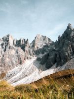 grass field near rock formation wallpaper