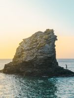 two people standing on rock formation surrounded b... wallpaper